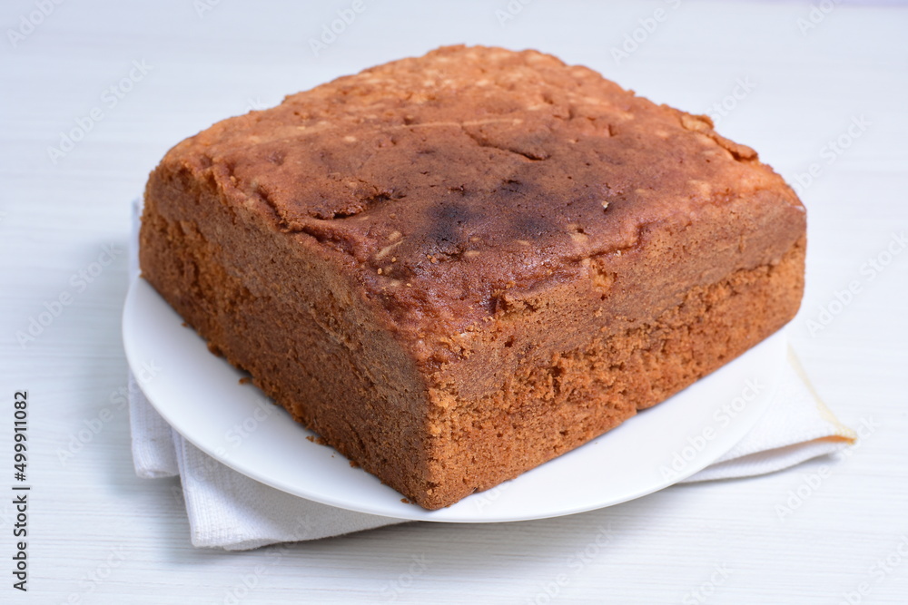 Homemade vanilla cake, displayed on plate and wooden background