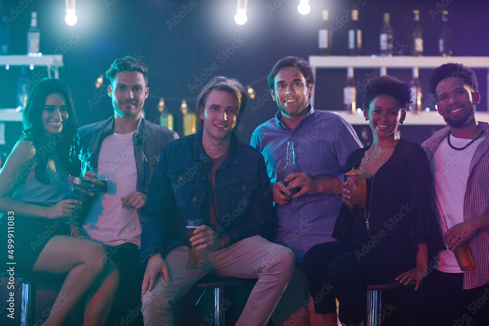 Good friends and good fun. Portrait of a group of happy friends enjoying drinks in a nightclub. Good friends and good fun. Portrait of a group of happy friends enjoying drinks in a nightclub.
