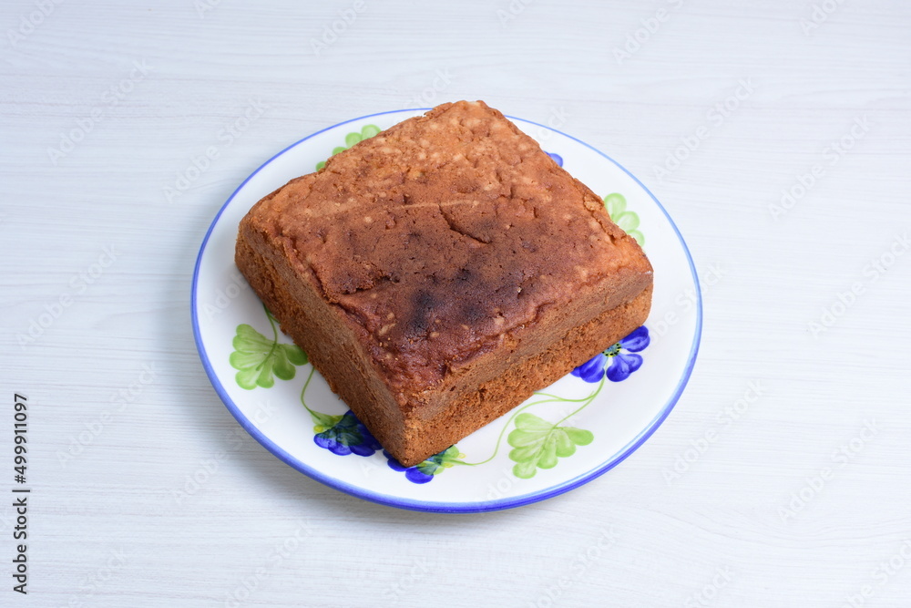 Homemade vanilla cake, displayed on plate and wooden background Homemade vanilla cake, displayed on plate and wooden background