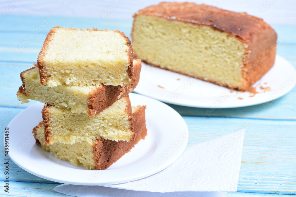 Homemade vanilla cake, displayed on a plate and portioned and on a wooden background Homemade vanilla cake, displayed on a plate and portioned and on a wooden background