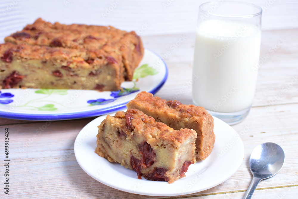 Fluffy bread cake with guava flavor accompanied by a glass of milk on a wooden background Fluffy bread cake with guava flavor accompanied by a glass of milk on a wooden background