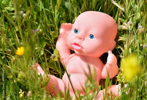 Muñeco bebé tradicional perdido entre la hierba