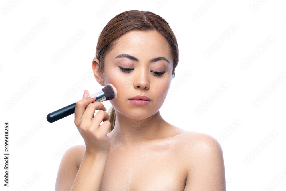 Close up portrait of a beautiful half naked woman with perfect, natural, clean and cosmetic skin and looking away. Hold makeup brush, make up in process. Isolated over white background. Close up portrait of a beautiful half naked woman with perfect, natural, clean and cosmetic skin and looking away. Hold makeup brush, make up in process. Isolated over white background.