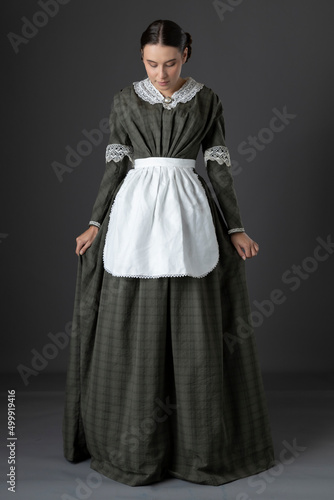 Foto A Victorian working class woman wearing a dark green checked bodice and skirt an