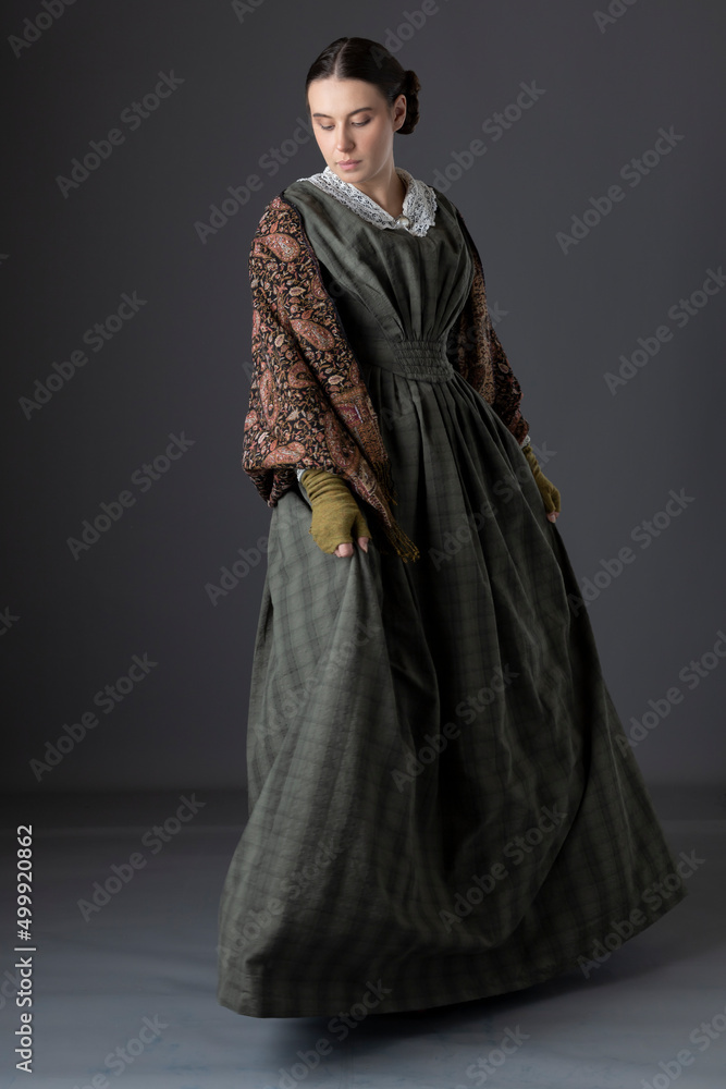 A Victorian working class woman wearing a green checked bodice and skirt with a lace collar and a paisley shawl A Victorian working class woman wearing a green checked bodice and skirt with a lace collar and a paisley shawl