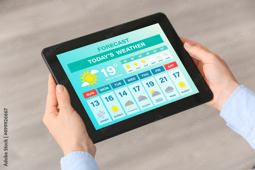 Young woman with tablet computer using weather forecast application, closeup Young woman with tablet computer using weather forecast application, closeup