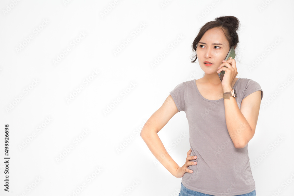 Beautiful Asian woman wearing grey casual shirt holding smartphone on white background and copy space. Cute Asian woman stressed talk something on the phone for social media concept Beautiful Asian woman wearing grey casual shirt holding smartphone on white background and copy space. Cute Asian woman stressed talk something on the phone for social media concept