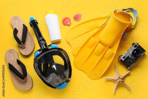 Beach accessories with snorkeling mask and photo camera on yellow background #499928264