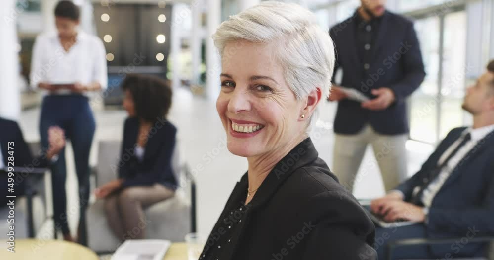 Dedicated leaders make all the difference to the team. 4k video footage of a mature businesswoman smiling in an office with her colleagues in the background. Dedicated leaders make all the difference to the team. 4k video footage of a mature businesswoman smiling in an office with her colleagues in the background.
