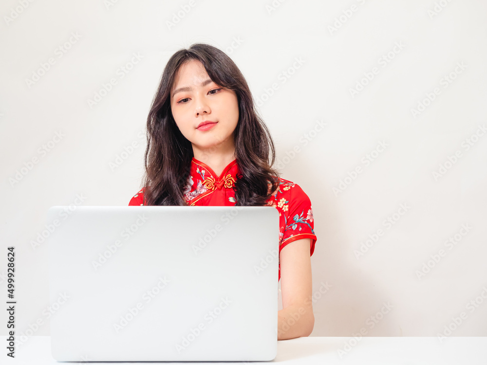 Asian young woman wearing traditional cheongsam qipao dress using laptop and credit card shopping online, e-commerce concept isolated on white background. Asian young woman wearing traditional cheongsam qipao dress using laptop and credit card shopping online, e-commerce concept isolated on white background.