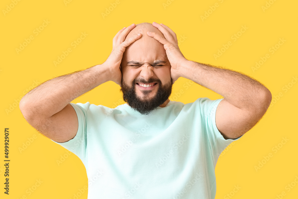 Stressed bald man on yellow background Stressed bald man on yellow background