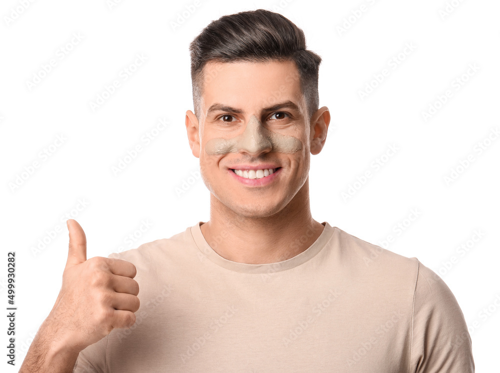 Handsome man with applied clay mask showing thumb-up on white background Handsome man with applied clay mask showing thumb-up on white background