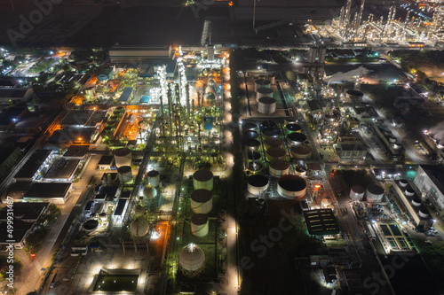 Aerial view of petrochemical oil refinery and sea in industrial engineering concept in Bangna district at night, Bangkok City, Thailand. Oil and gas tanks pipelines in industry © Sathit Trakunpunlert