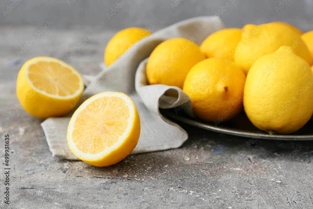 Plate of fresh lemons on grey table, closeup Plate of fresh lemons on grey table, closeup