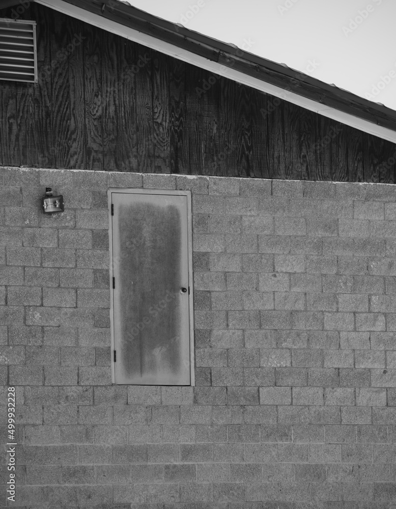 wooden door to nowhere in grey concrete block exterior wall of building