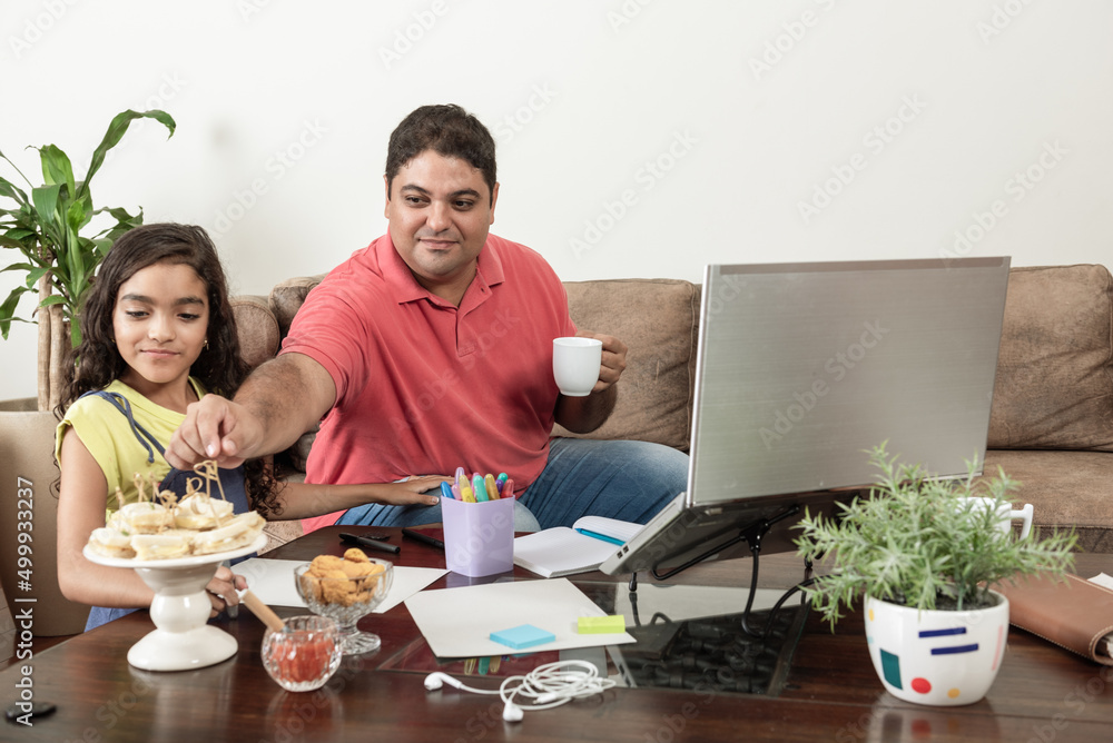 Pai trabalhando com filha fazendo dever de casa na sala de estar Pai trabalhando com filha fazendo dever de casa na sala de estar