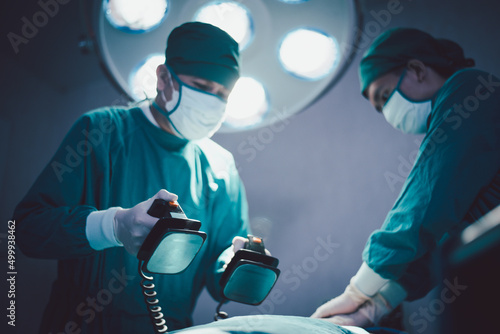 Medical urgency doctor using defibrillator during surgical operation a patient in hospital operating room photo