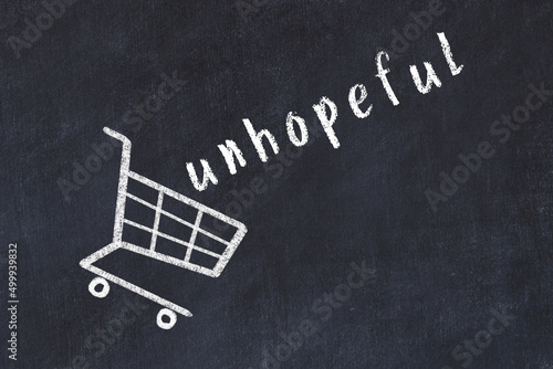 Chalk drawing of shopping cart and word unhopeful on black chalboard. Concept of globalization and mass consuming photo