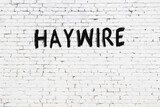 White wall with black paint inscription haywire on it