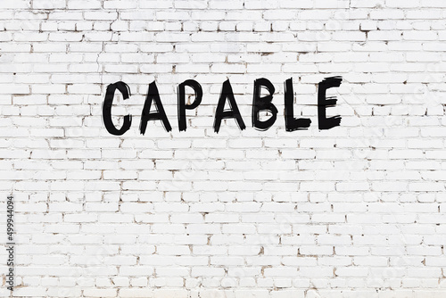 White wall with black paint inscription capable on it