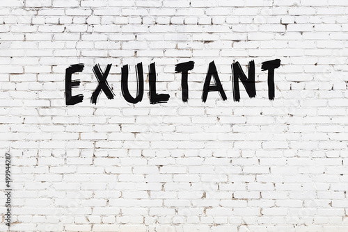 Foto White wall with black paint inscription exultant on it