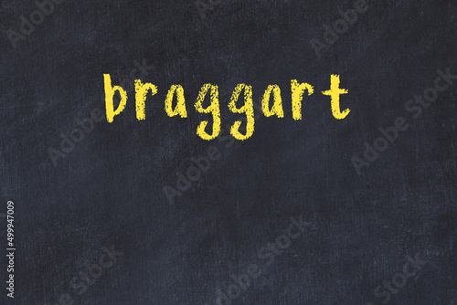 College chalk desk with the word braggart written on in photo