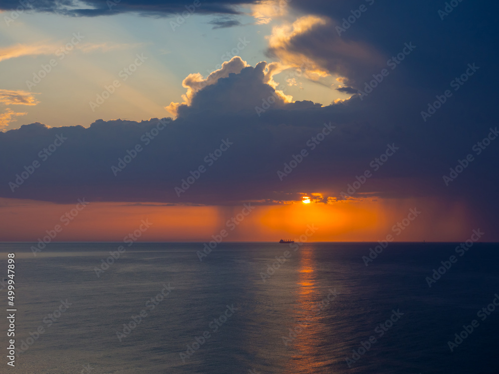 Thunderstorm at sea at dusk. The Beauty of Sunrise waves. Seascape with dramatic cloudy sky and rising sun in Spain. The view from beach