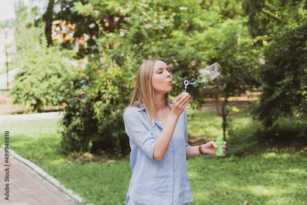 young woman blowing bubbles in the park and having fun young woman blowing bubbles in the park and having fun