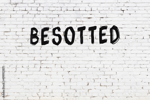 Tableau sur toile Inscription besotted painted on white brick wall