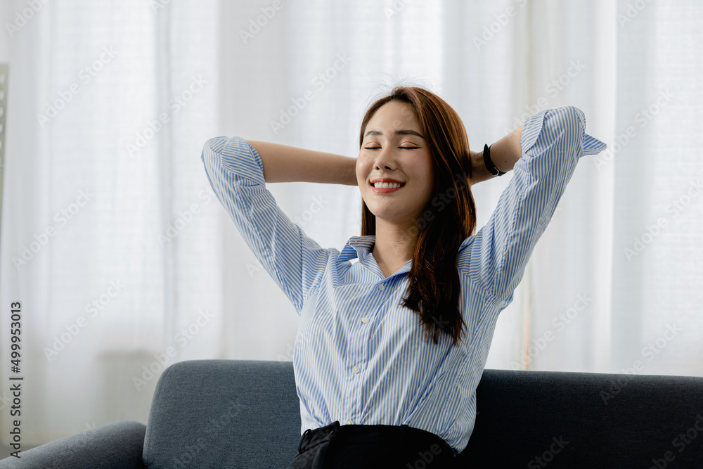 woman stretching relax. She is relaxing on the sofa in the living room on vacation. She does yoga poses to relax after a hard day's work. The idea of taking a break from hard work. woman stretching relax. She is relaxing on the sofa in the living room on vacation. She does yoga poses to relax after a hard day's work. The idea of taking a break from hard work.