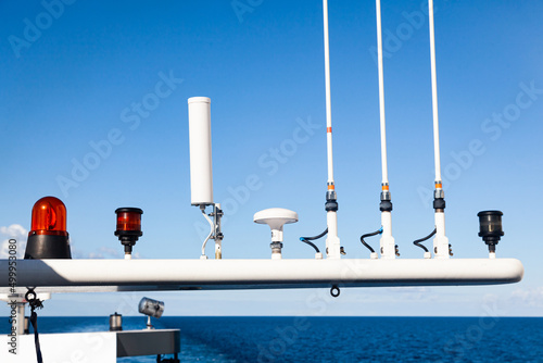 The roof of the yacht with navigational equipment against the background of the sea and sky. Antennas, radars, signal lights, satellite dishes and equipment.