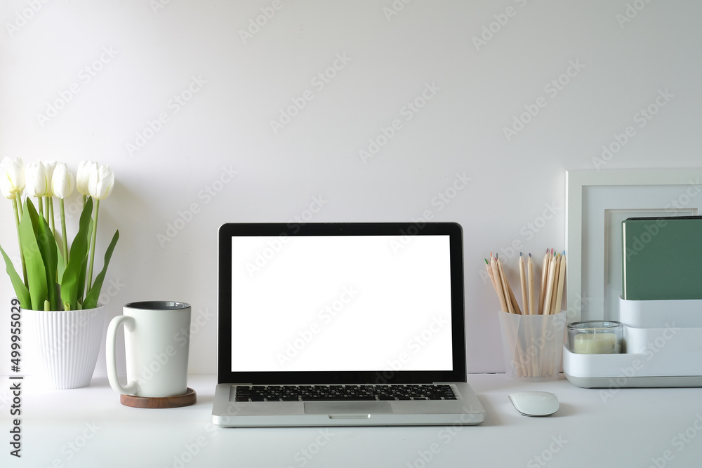 Front view laptop computer with blank screen, flower pot, coffee cup and picture frame on white table. Front view laptop computer with blank screen, flower pot, coffee cup and picture frame on white table.
