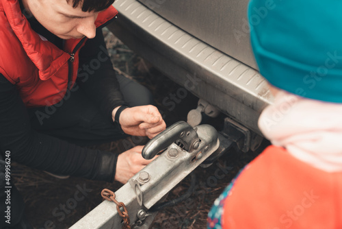 Man connects a trailer to the towbar of his car