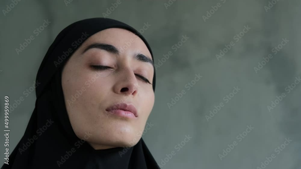 Close-up of a representative of the fair sex, a Muslim woman looking at the camera. She looks modest and frequent. Cruel rules in relation to women in Islam, the obligatory wearing of the hijab. Close-up of a representative of the fair sex, a Muslim woman looking at the camera. She looks modest and frequent. Cruel rules in relation to women in Islam, the obligatory wearing of the hijab.