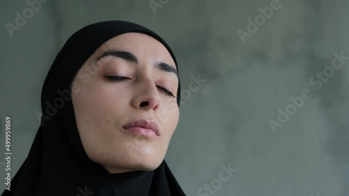 Close-up of a representative of the fair sex, a Muslim woman looking at the camera. She looks modest and frequent. Cruel rules in relation to women in Islam, the obligatory wearing of the hijab. photo