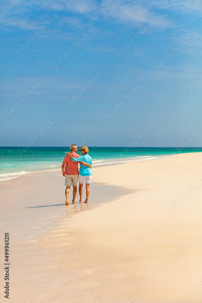 Travel retired couple walking barefoot on sandy beach Travel retired couple walking barefoot on sandy beach