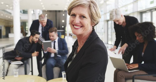 Shes sure of her abilities to succeed. 4k video footage of a businesswoman smiling in an office with her colleagues in the background. photo