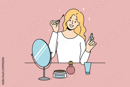 Smiling girl sit at table doing makeup put mascara. Happy young woman look in mirror apply beauty cosmetics products. Daily routine and preparation. Cosmetology. Vector illustration. 