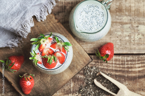 Chia pudding with strawberries. Homemade fresh chia pudding wisth strawberries served in glass on rustic wooden table. photo