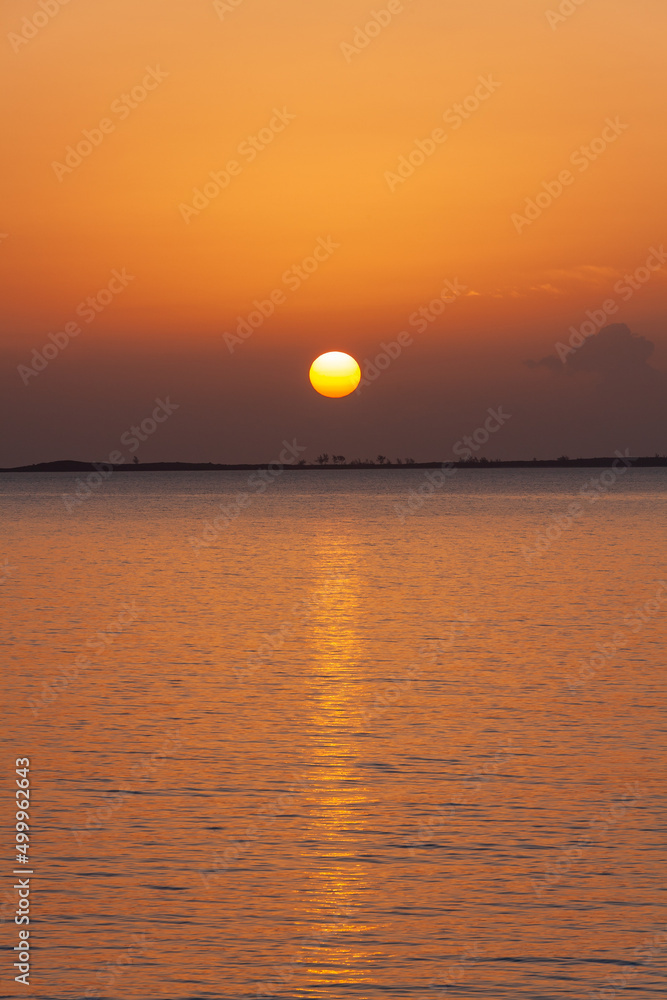 Orange sky with sunset reflection on tropical ocean