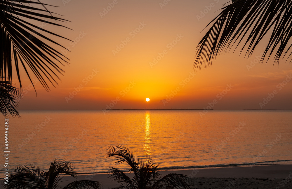 Tropical island resort with tranquil ocean at sunset