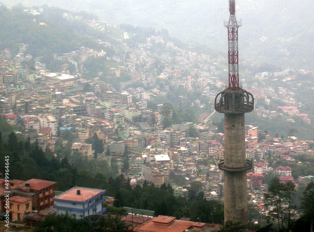 Fototapeta premium A panoramic view of Gangtok city with concrete jungle amid TV Tower as seen from Ganesh Tok in Gangtok, Sikkim. Sikkim comes under 4th seismic zone in India so high buildings is banned here.