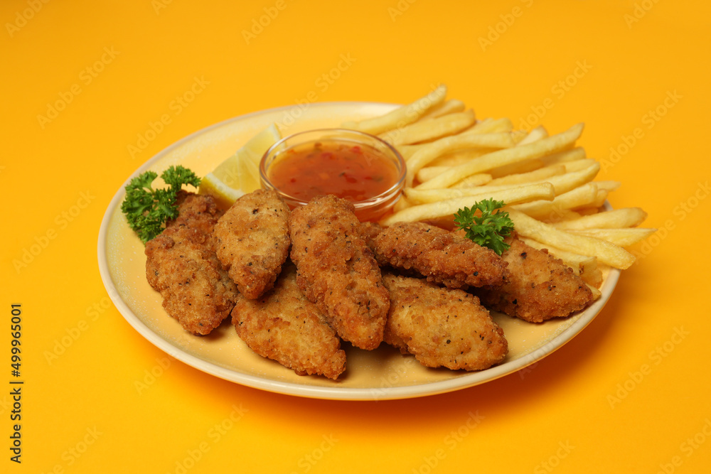 Concept of tasty food with chicken strips on orange background Concept of tasty food with chicken strips on orange background