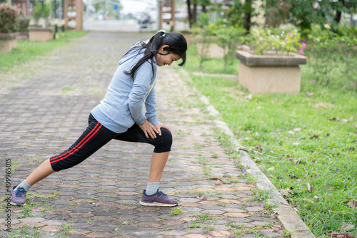 A young asian woman do stretching legs before running in city park.Stretch your body before running.