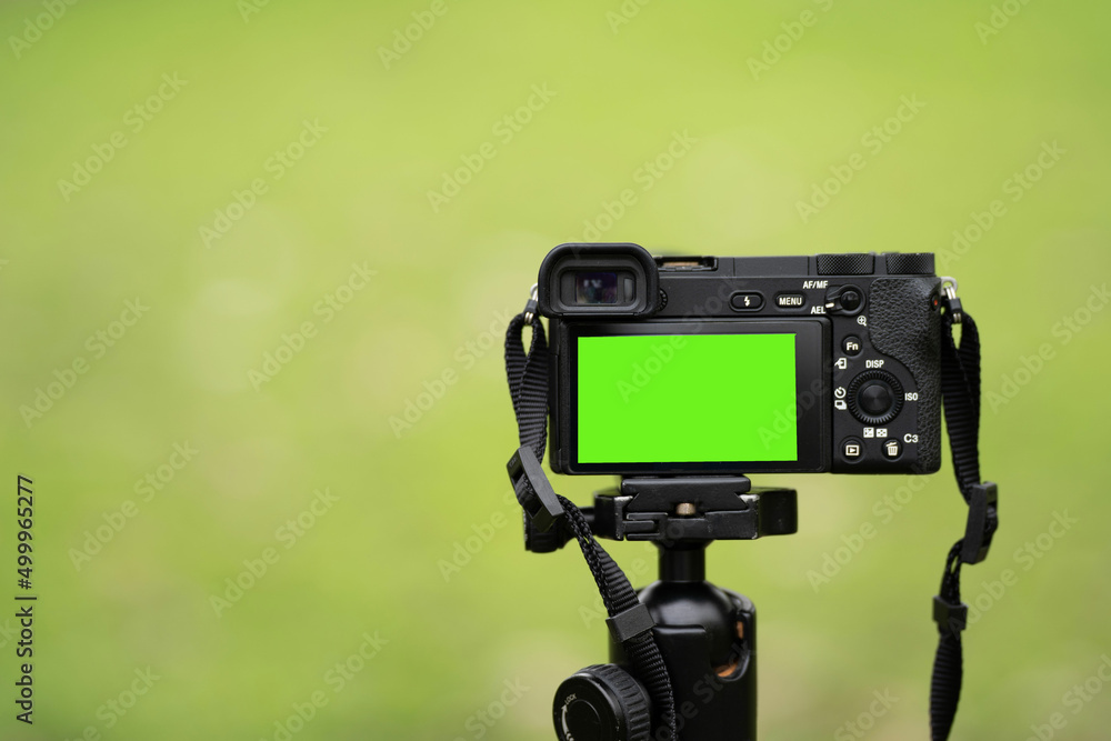 Fototapeta premium Mirrorless camera with green screen on the monopod . Green screen camera