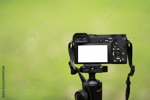 Mirrorless camera with green screen on monopod, white screen camera photo
