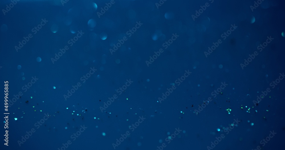 Bokeh glow overlay. Underwater sparkles. Sea bubbles. Defocused blue color shiny round flecks light reflection on dark abstract background. Bokeh glow overlay. Underwater sparkles. Sea bubbles. Defocused blue color shiny round flecks light reflection on dark abstract background.