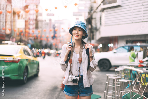 Φωτογραφία Young adult asian woman traveller backpack traveling in city lifestyle chinatown street food  with bokeh background