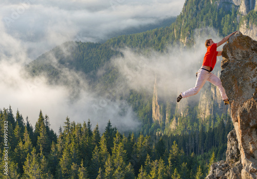 Skillful rock climber climbing in beautiful scene at sunrise  photo