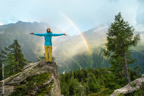 Konstfotografi Woman standing with arms outstretched out in front of a beautiful scenery with m
